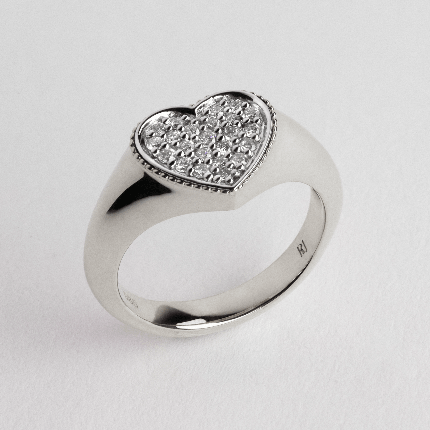 White gold heart-shaped ring with embedded diamonds on a light gray background