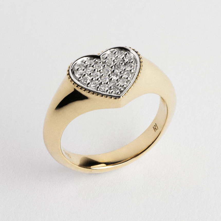 Gold ring with a heart-shaped pave diamonds set on a light gray background